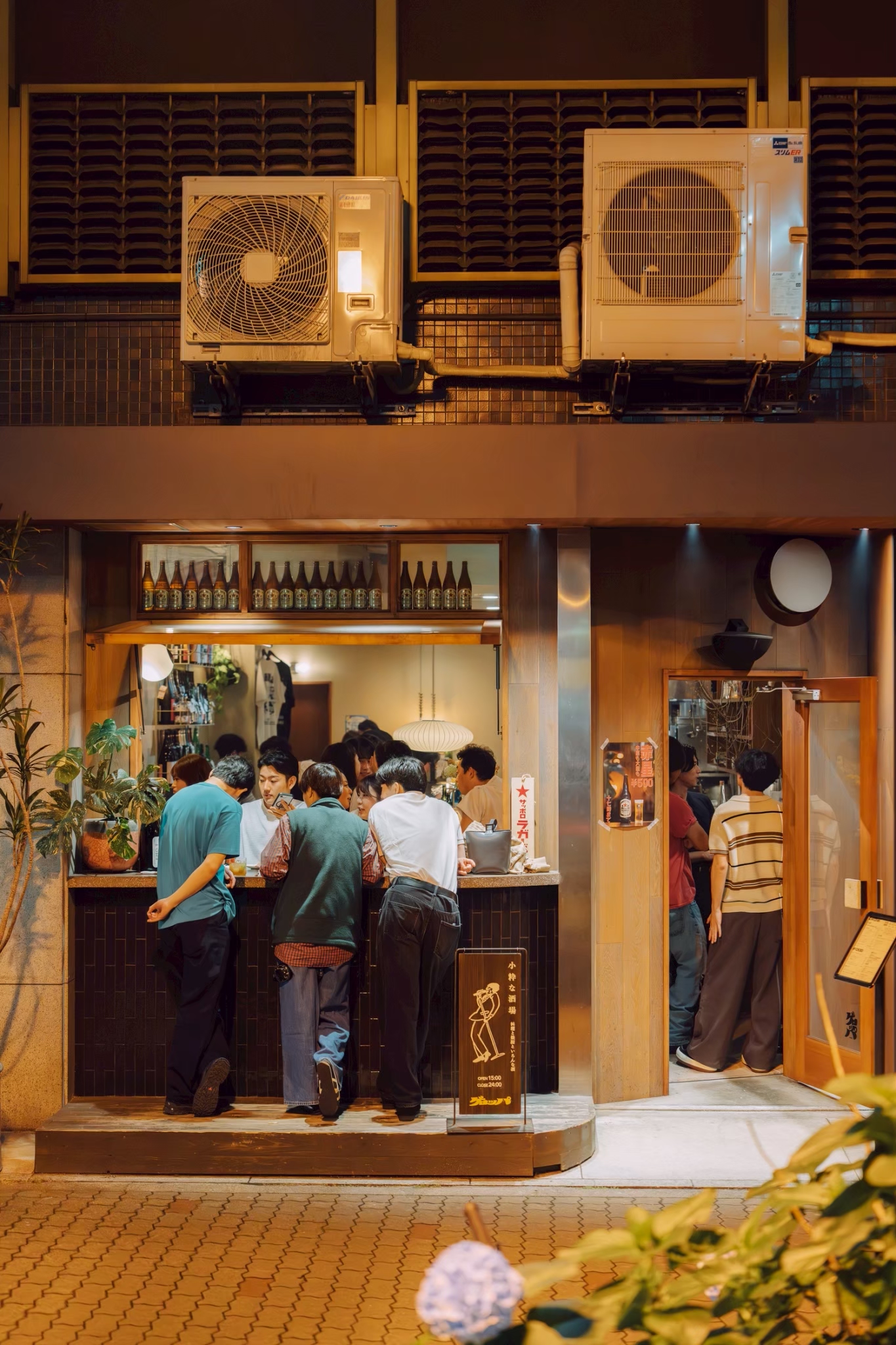 夜の店先のカウンターで賑わうお客様たち