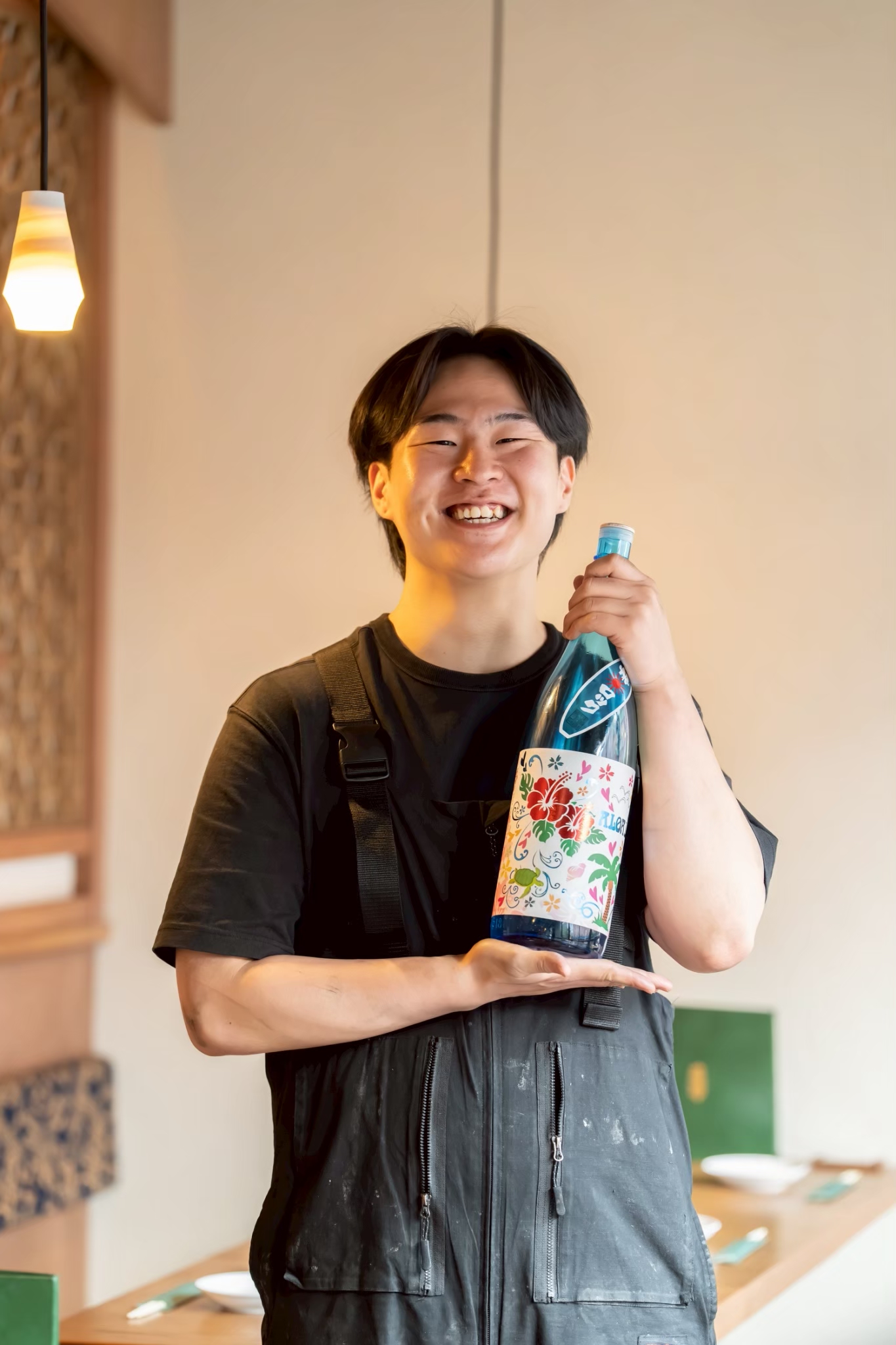 日本酒を手に笑顔を見せるスタッフ
