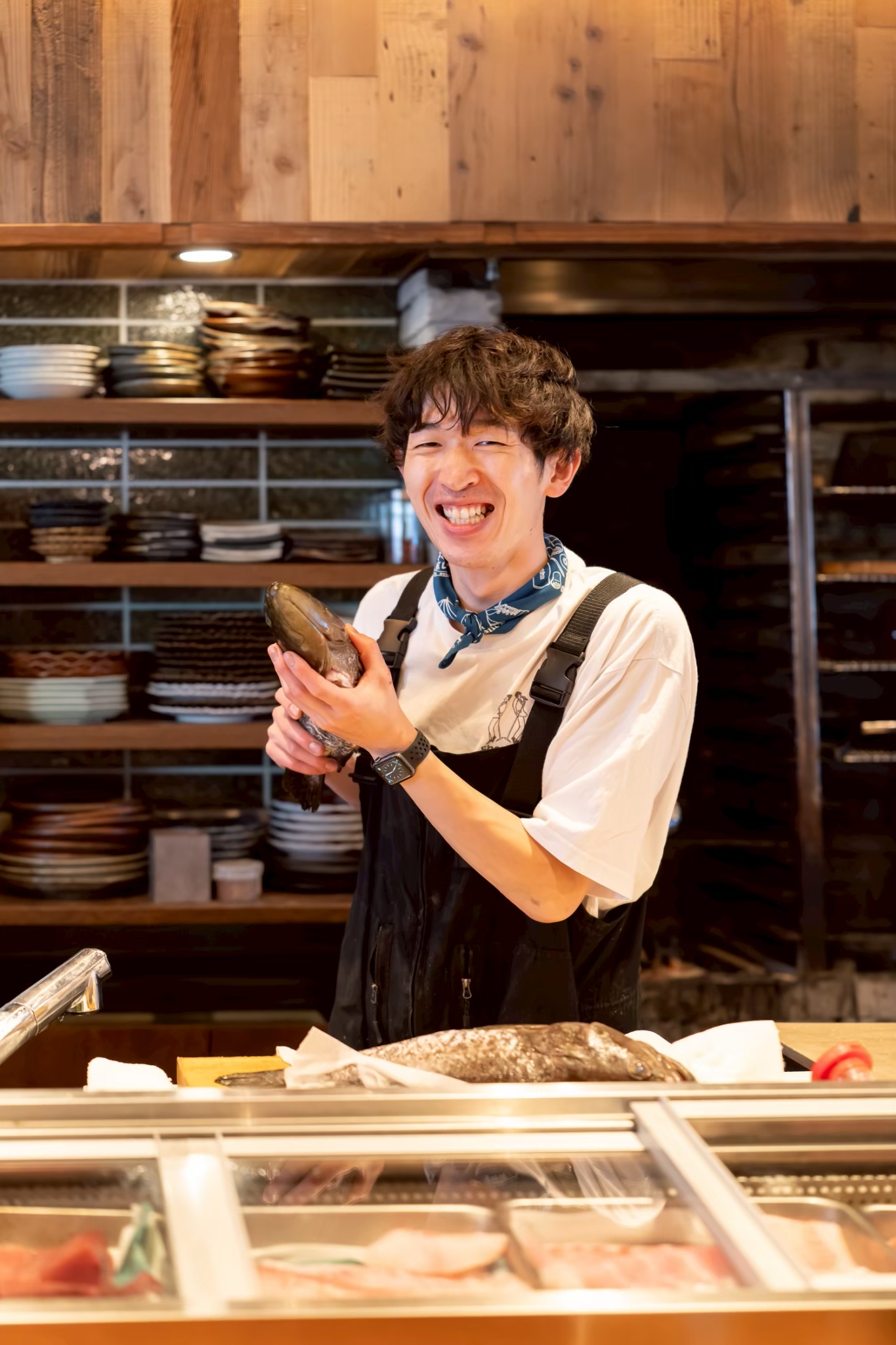 仕入れたばかりの魚を手に笑顔を見せる食財とお酒 の/すぺゐすのスタッフ